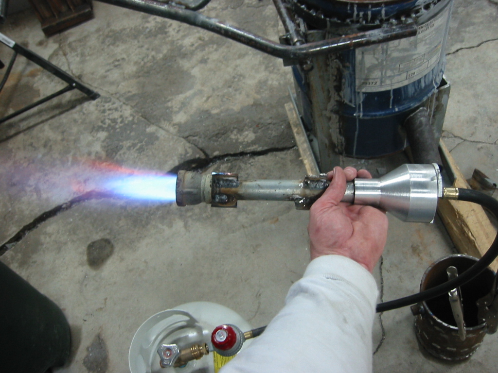 Burner make from 3/4 inch pipe, a 1 inch by 3/4 reducer on one end and a bell turned from aluminum on the other. A brace is welded into the bell and that is drilled and threaded for the gas hose.