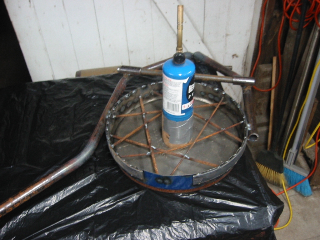 Pipe frame welded to the top of the oil drum lid with rods to reinforce the Mizzou and a bottle to form the vent.
